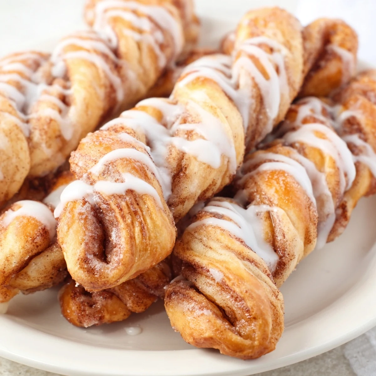 Golden, glazed air-fryer cinnamon roll twists, warm and aromatic, perfect for a quick breakfast.