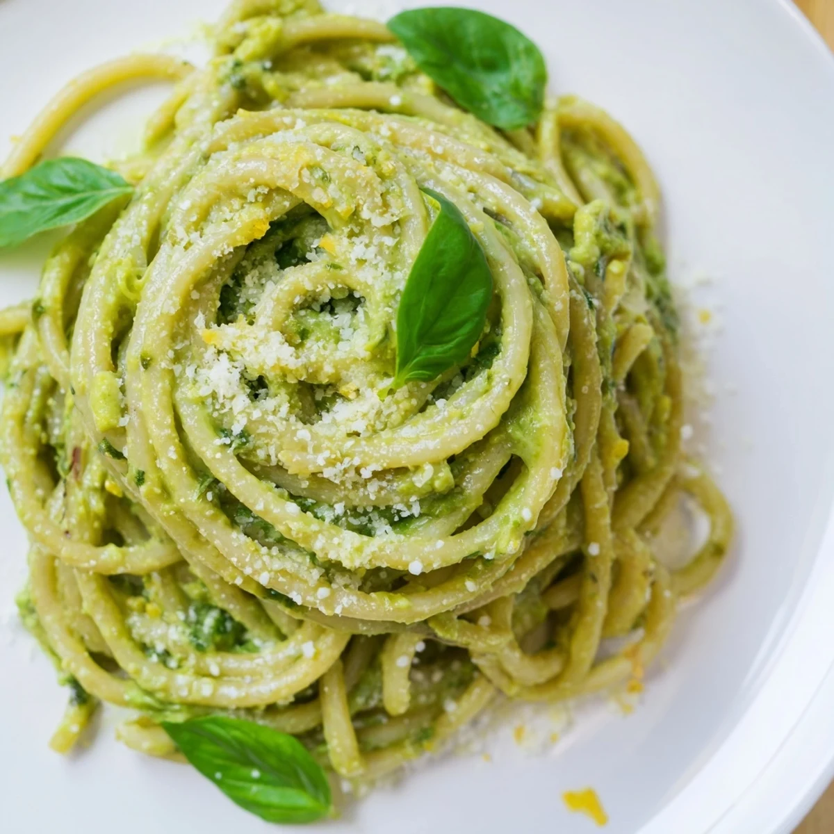 Vibrant creamy avocado pasta served, boasting ribbons of pasta coated in the green sauce.