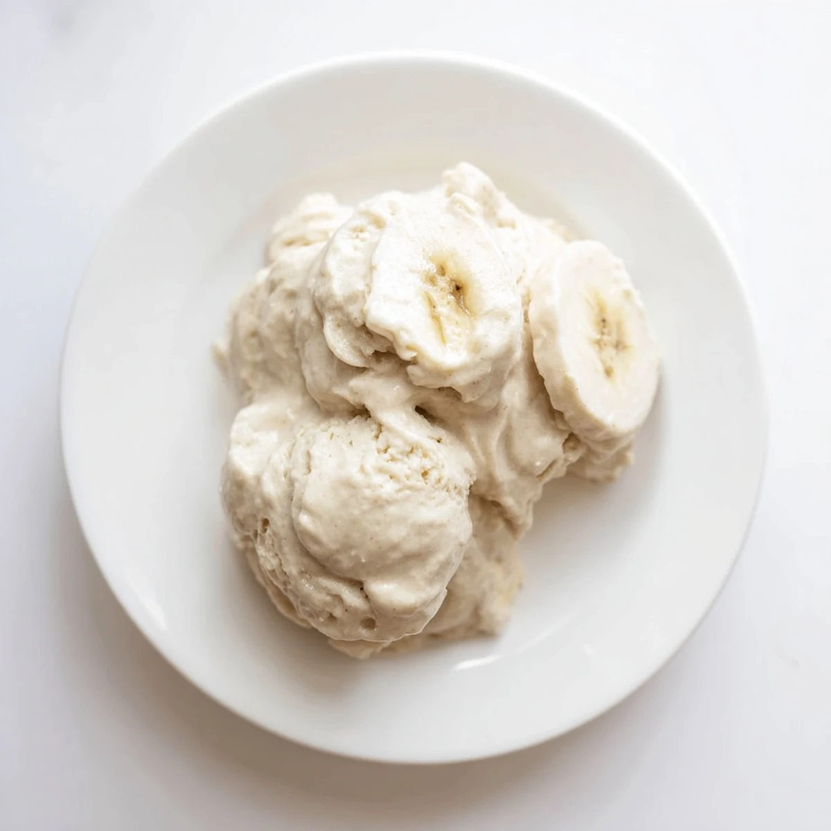 Smooth, homemade 2-Ingredient Banana Ice Cream with a swirl of vanilla, ready to enjoy.