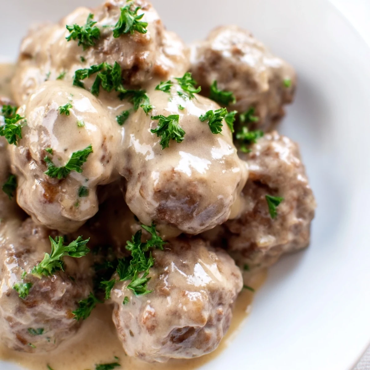 Tender Swedish Meatballs, freshly cooked and simmering in a creamy sauce, ready for serving.