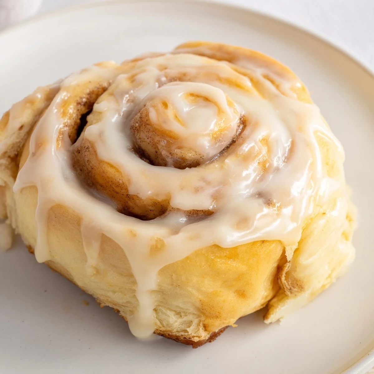 Golden-brown Pillow Soft Cinnamon Rolls drizzled with cream cheese glaze, perfect for a cozy weekend brunch or breakfast.  