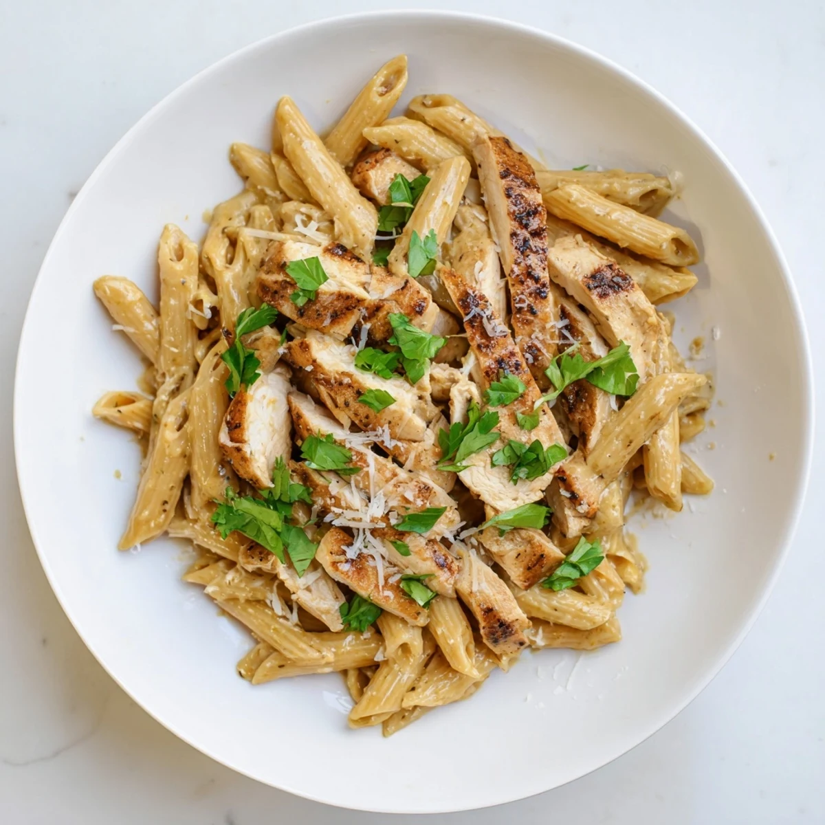 Sweet and smoky honey chipotle sauce coats penne pasta and sliced chicken in this dish.