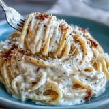 Fork twirling spaghetti cacio e pepe in a rustic Italian kitchen, showcasing the creamy Pecorino sauce and freshly cracked pepper.