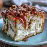 Warm Caramel Cream Cheese Bread slices on a plate, drizzled with caramel sauce and paired with a glass of milk.