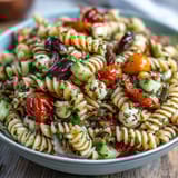 Vibrant pasta salad with cherry tomatoes, cucumbers, and red peppers tossed in zesty Italian dressing for a refreshing summer meal.