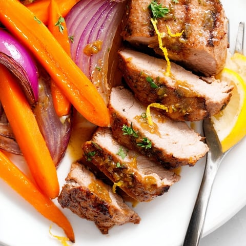 Juicy one-pan garlic herb pork tenderloin and carrots roasted with fresh herbs and lemon.
