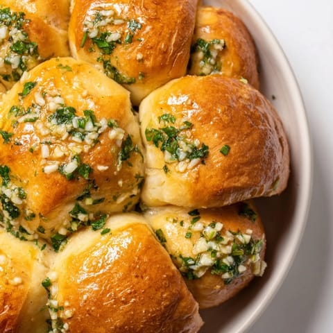 Freshly baked Garlic Butter Bread with melted butter and parsley, perfect for sharing at a family dinner.