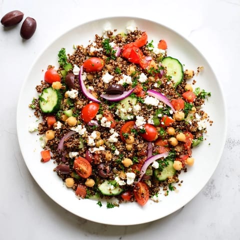 A vibrant bowl of Greek Power Salad topped with feta, parsley, and a zesty vinaigrette.