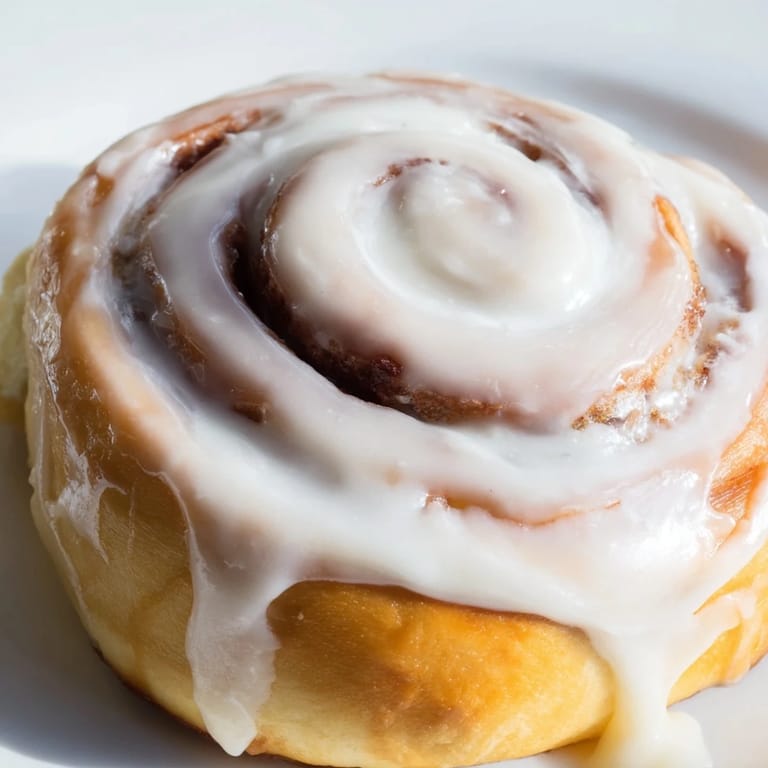 Soft, fluffy Pillow Soft Cinnamon Rolls with buttery cinnamon sugar filling and a sweet vanilla glaze, ready to serve.